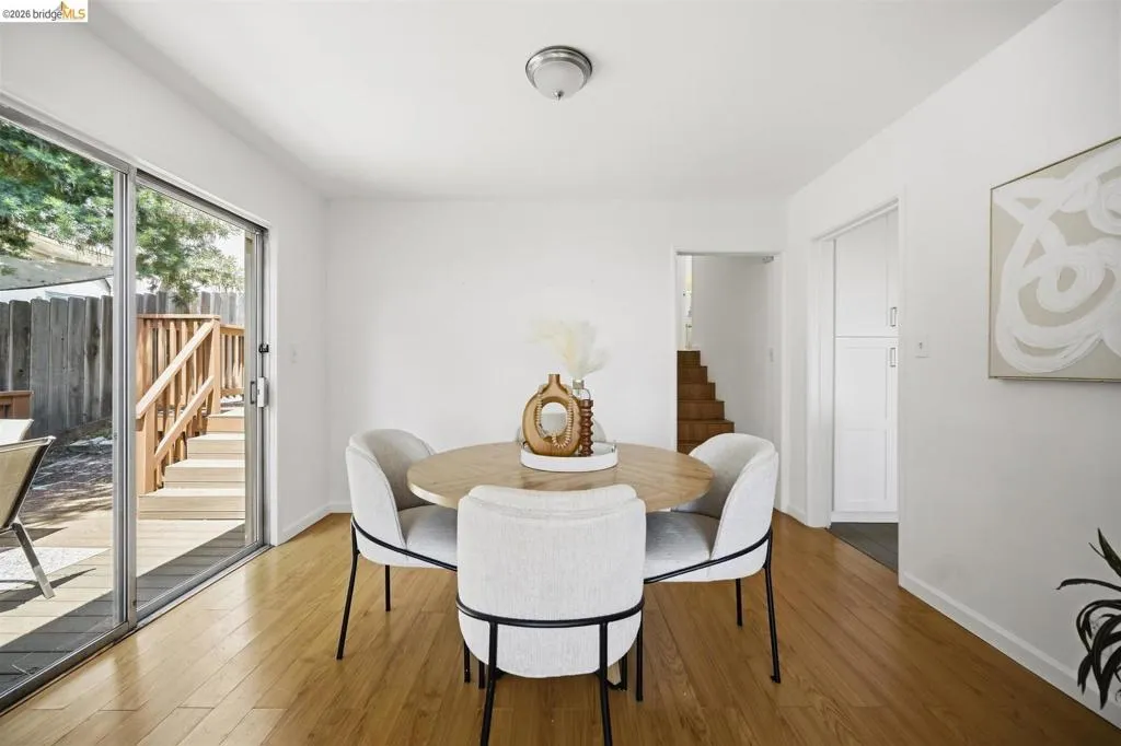 Wood-finish flooring throughout, featuring a sliding glass door leading to an outdoor deck with railings