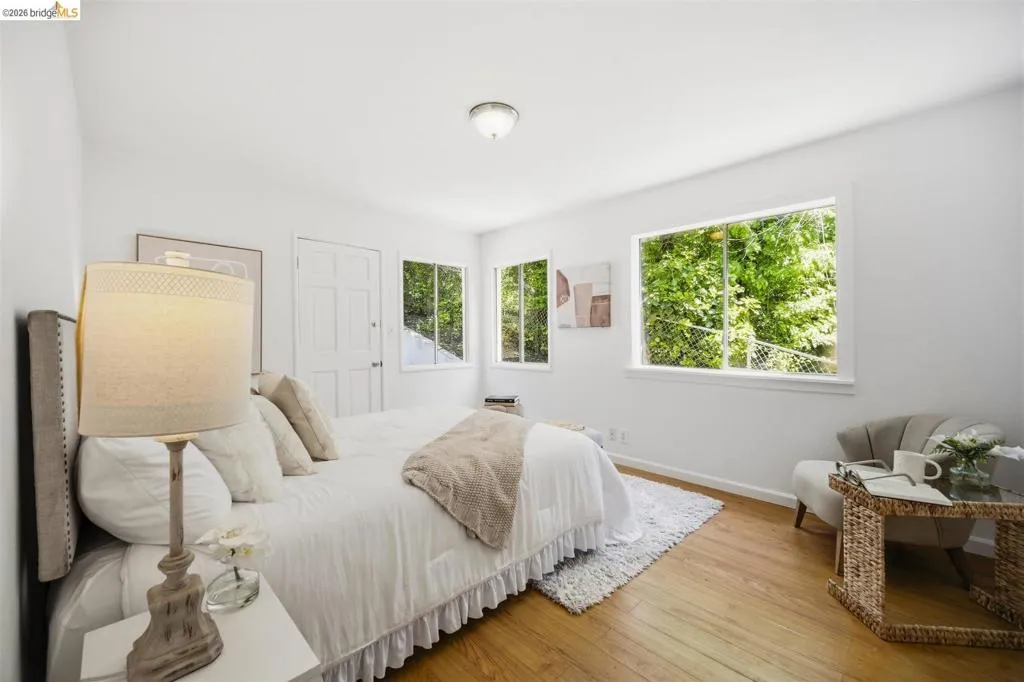 Bedroom featuring light wood-finish flooring and multiple windows