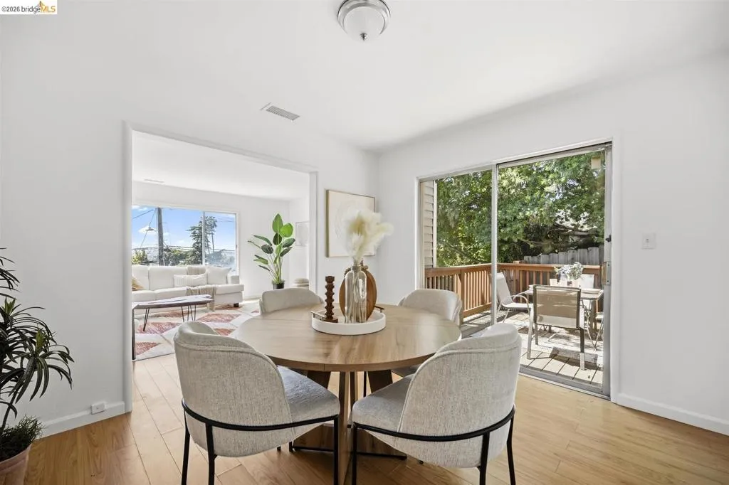 Dining area with wood-finish flooring, featuring a sliding glass door to an outdoor deck