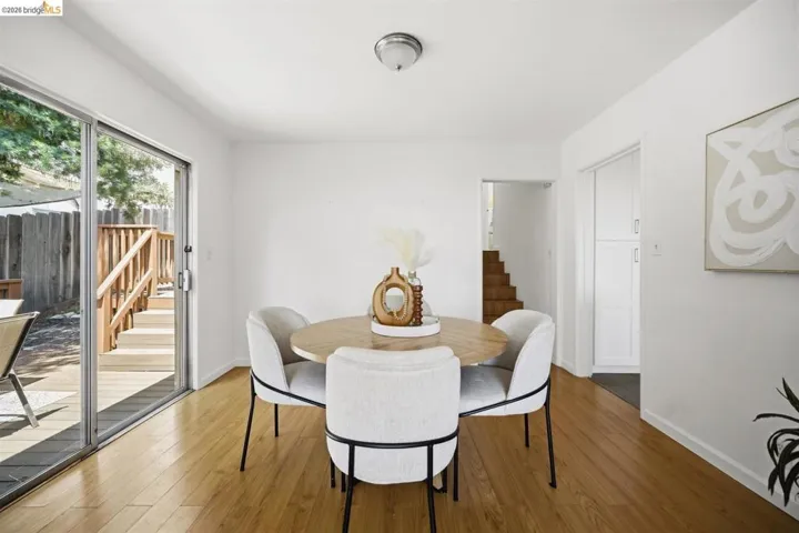 Wood-finish flooring throughout, featuring a sliding glass door leading to an outdoor deck with railings