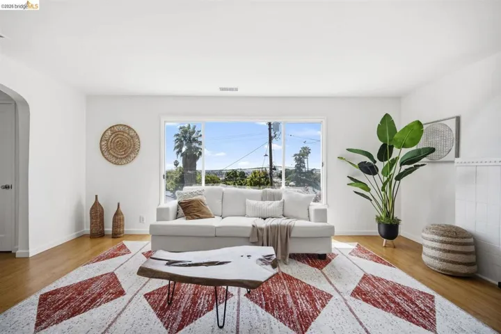 Spacious living area featuring light wood-finish flooring and a wide picture window
