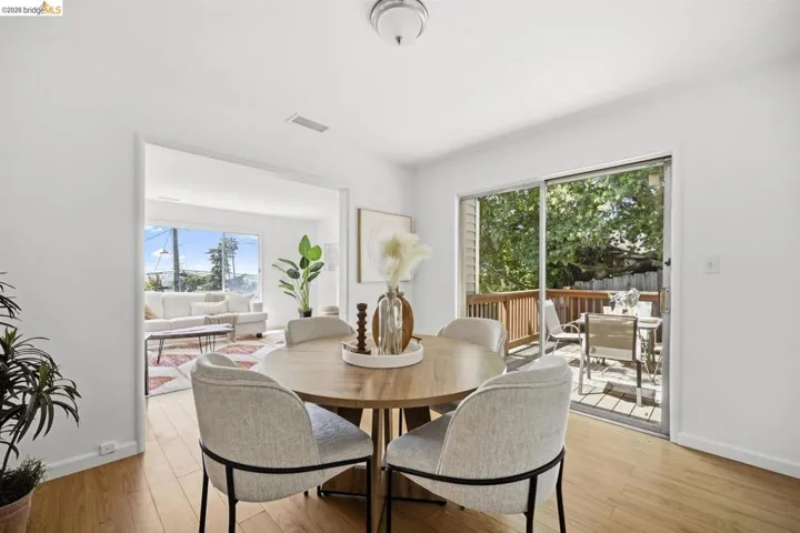 Dining area with wood-finish flooring, featuring a sliding glass door to an outdoor deck