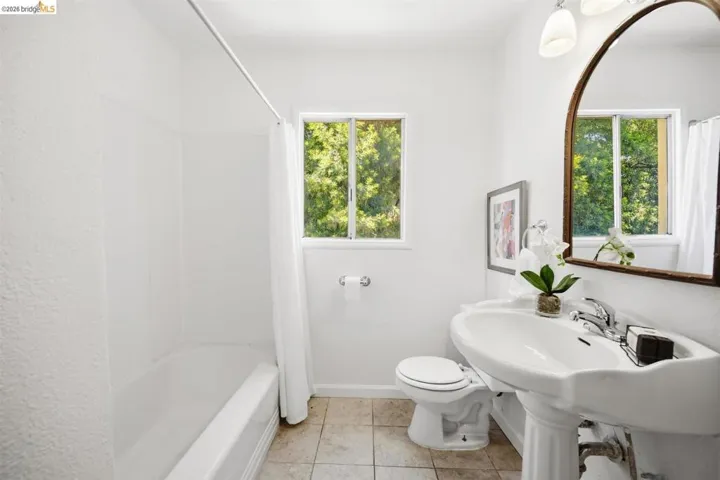 Bathroom featuring a white pedestal sink, tiled flooring, and a white tub with​​‌​​​​‌​​‌‌​​‌​​​‌‌​​​‌​​‌‌​​‌‌​​‌‌​​​​ shower