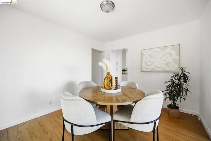 Dining area featuring wood-finish flooring, white walls, and a ceiling-mounted light fixture