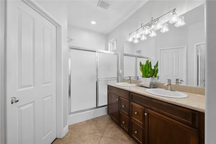 Double Sink Vanity and Granite Counter Tops in the Primary Suite with Upgraded Light Fixtures and Custom Walk-In Closet.
