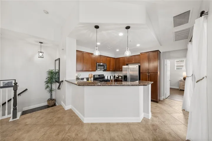 Open Concept Kitchen with Granite Counter Tops and warm tone wood Cabinets.