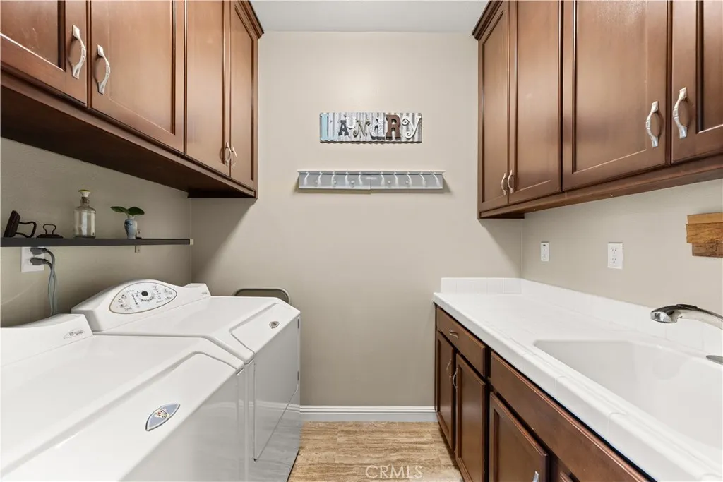 Laundry room downstairs with barn doors, custom cabinets, and utility sink