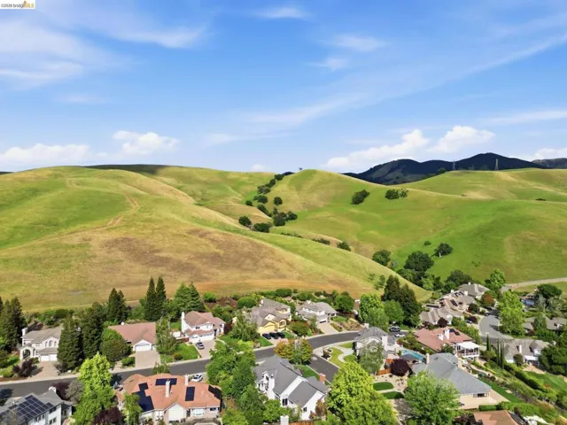 Expansive green hills provide a natural backdrop for this residential area