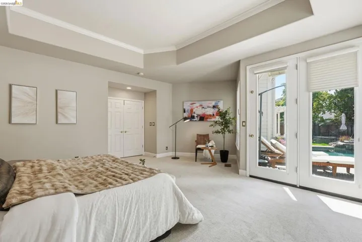 Carpeted room featuring a double French door entry to an outdoor space with a pool