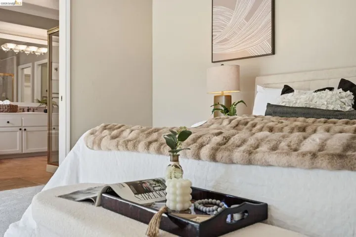 Spacious bedroom with an upholstered headboard, neutral wall tones, and carpet flooring