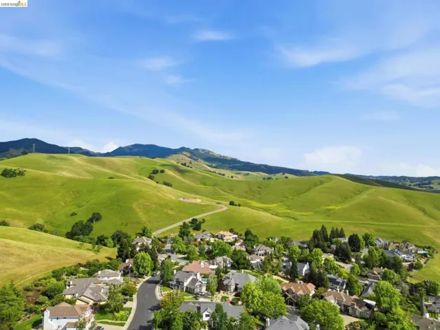 Residential community nestled against rolling green hills