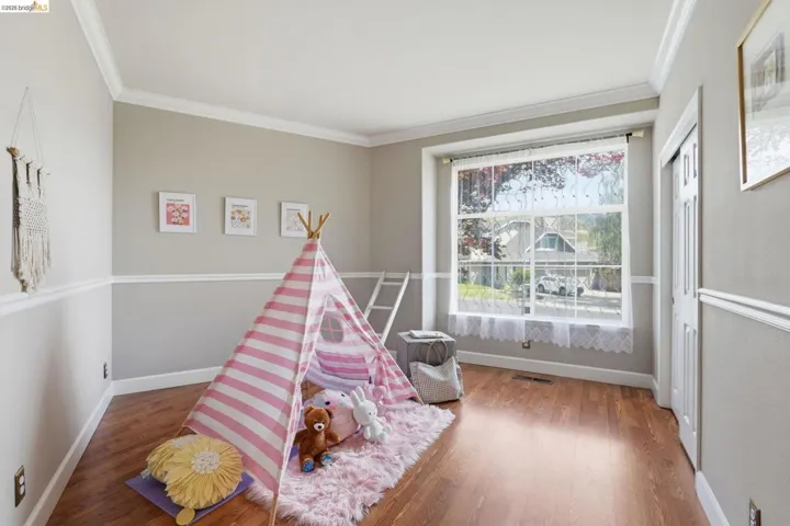 Hardwood-style flooring with baseboard and crown molding