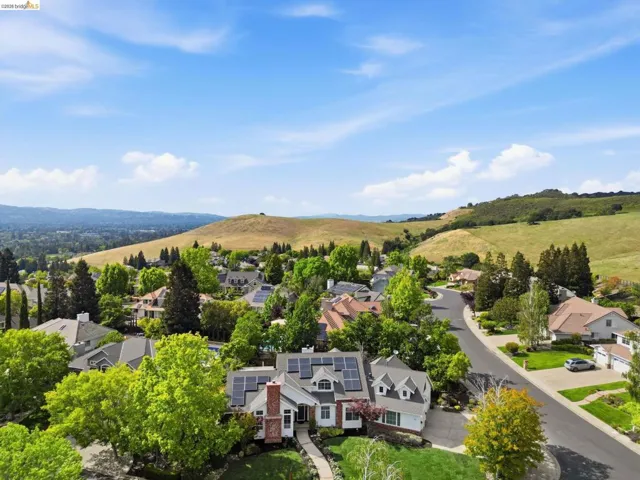 Aerial perspective showcasing a residential community with rolling hills and abundant trees