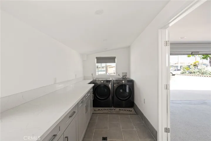 The garage has an additional room with cabinetry and laundry