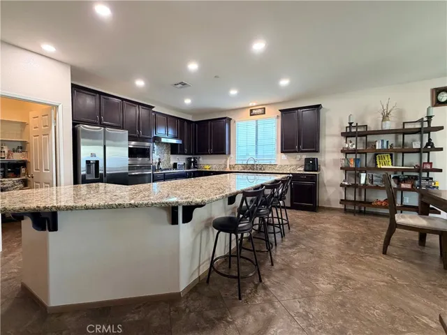Breakfast bar alone has room to seat 6 people comfortably. Note the walk-in pantry next to the fridge