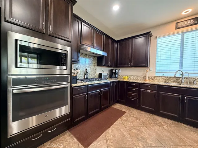 Close up of the wall oven and microwave above it. Also note the hood fan above the gas cooktop