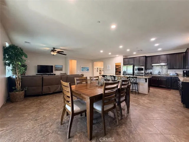View from the dining room area to the kitchen/living room. This space can comfortably seats 11 - 14 people between the dining area + breakfast eating bar on the island