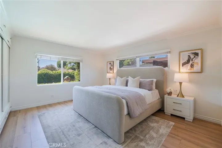Large primary bedroom in the rear with a beautiful view of the pool and greenery in the back yard.