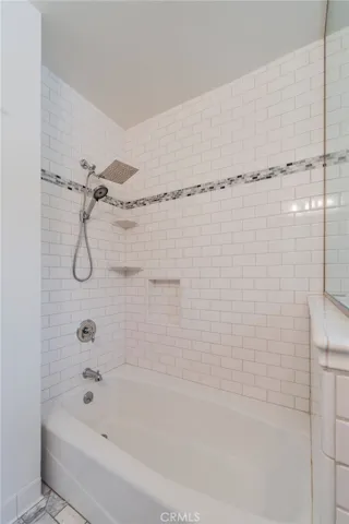 Shower in tub with modern tiles.