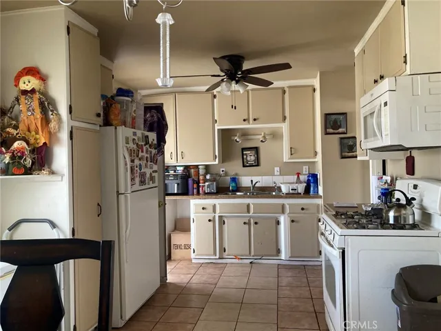 Kitchen has ceiling fan, lots of cabinets and a pantry