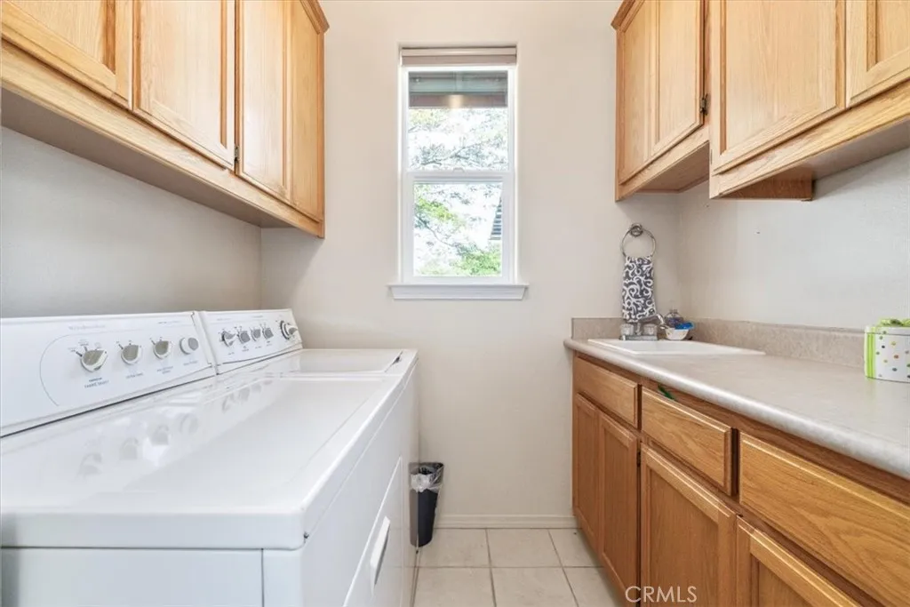 Large laundry room with sink plus ample storage and counter space