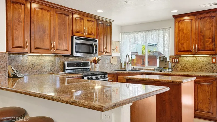 Granite countertops and a matching granite backsplash are nice touches throughout the kitchen.