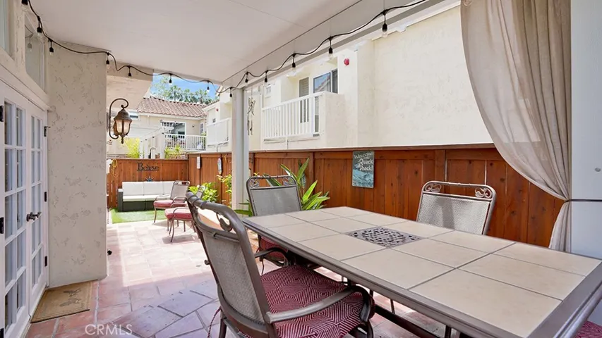 The elevated patio area is covered by a vinyl patio cover that provides both shade and privacy.
