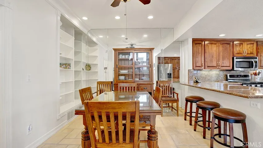 The dining room has a mirrored wall as well as some built-in cabinetry.