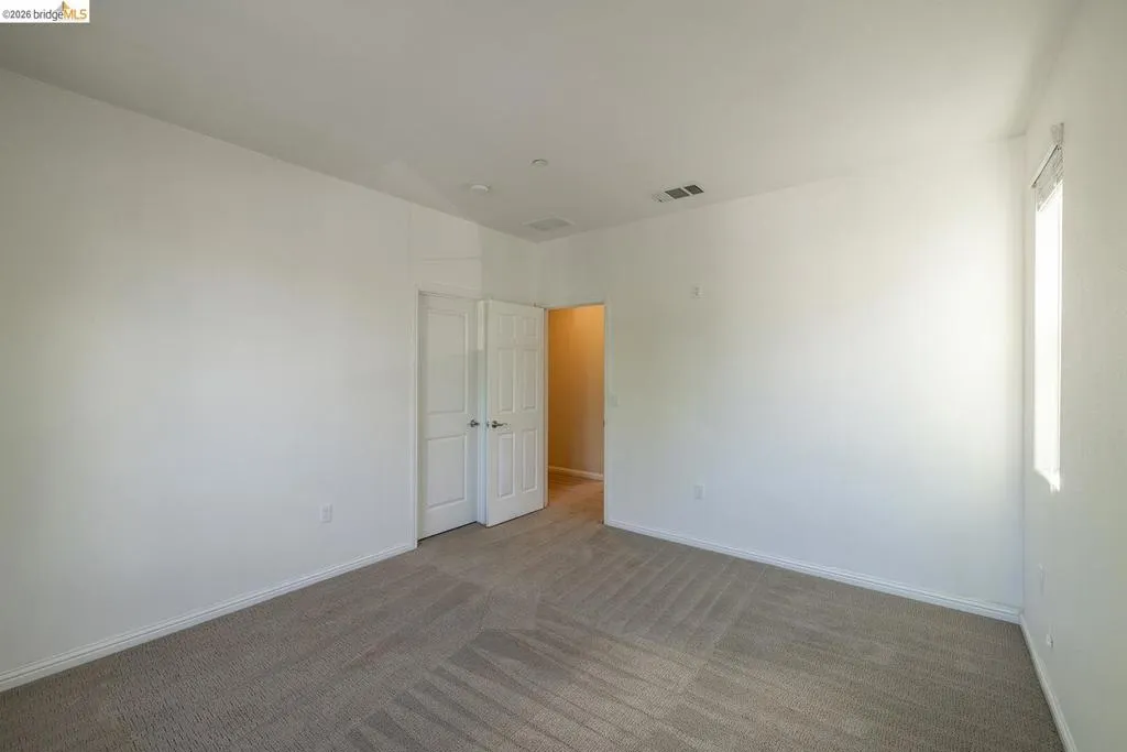 Spacious room with light-colored carpet flooring and white painted walls