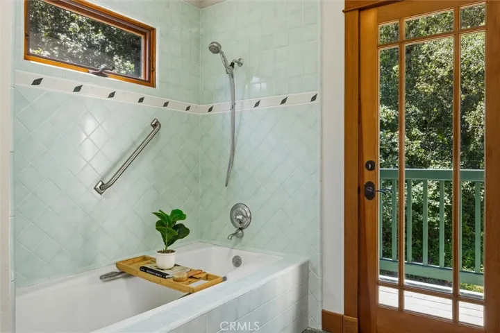 Soaking tub/shower with french door to balcondy