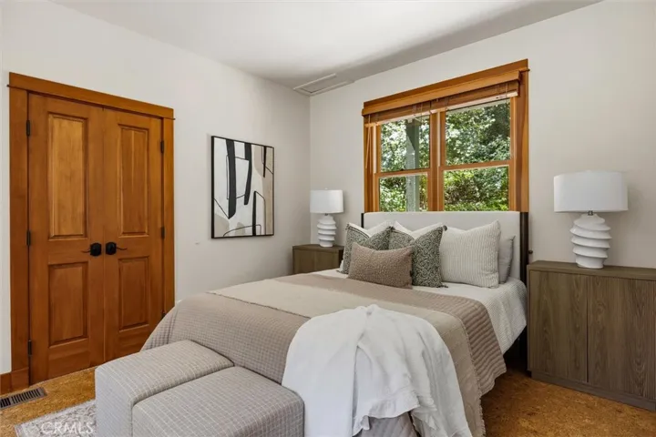 first floor bedroom 1, with cork flooring , a built in desk and shelves and a large closet