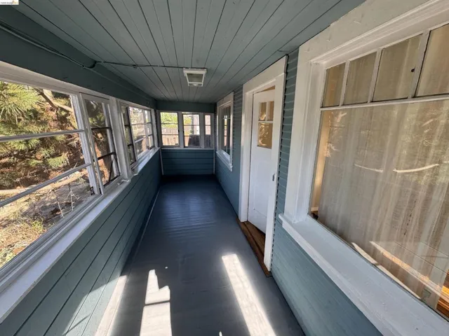 Unfurnished sunroom featuring wooden ceiling, wood finished floors, and wood walls
