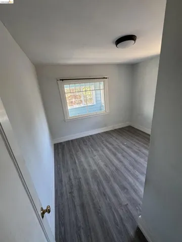Spare room with dark wood-type flooring