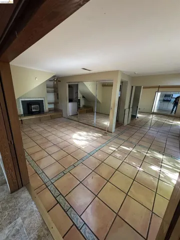 Unfurnished living room with light tile patterned floors and ceiling fan