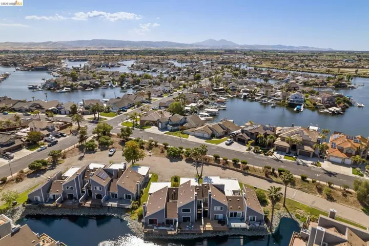 Aerial perspective of a waterfront community featuring canal-front residences and established streetscapes