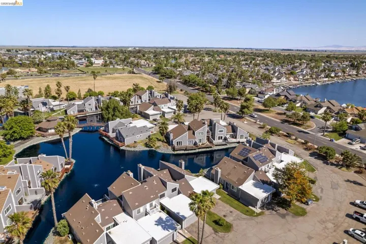 Waterfront residences with private docks and solar panels, surrounded by mature palm trees and lush landscaping