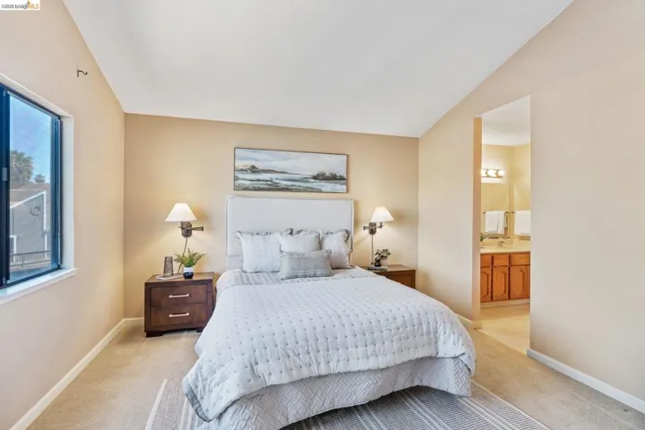 Carpeted bedroom featuring a window, neutral wall paint, and a textured headboard