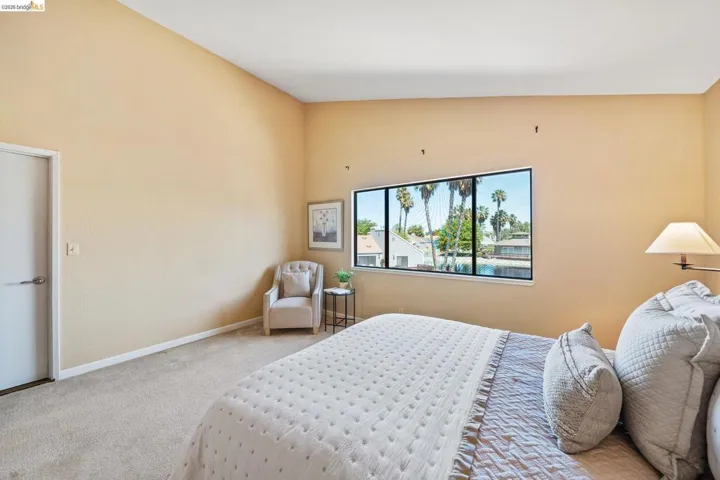 Expansive window offering water and palm tree scenery