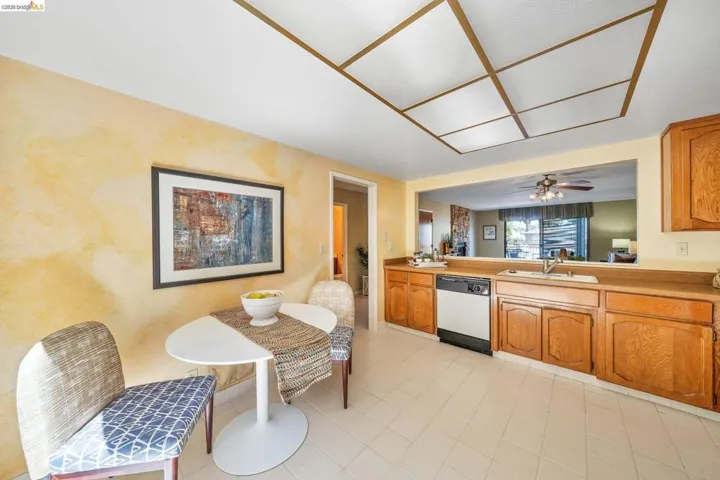 Kitchen featuring wood-finish cabinetry, light-toned countertops, and a double basin sink