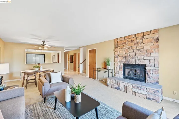 Spacious living area featuring a stone-clad fireplace and hearth