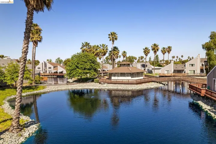 Waterfront community featuring a central gazebo structure, extensive wooden decking, and surrounding residences with private balconies