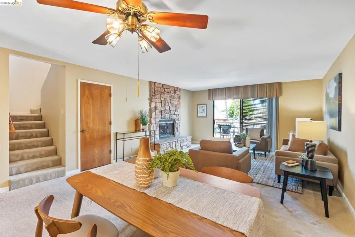 Open living area featuring a stone-clad fireplace and sliding glass door access to an exterior space