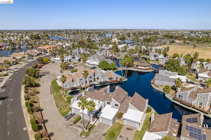Aerial depiction of a residential community featuring waterways and diverse architectural styles