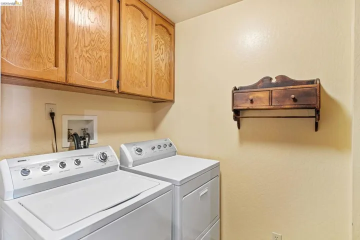 Utility area featuring upper wood cabinetry and light-toned walls