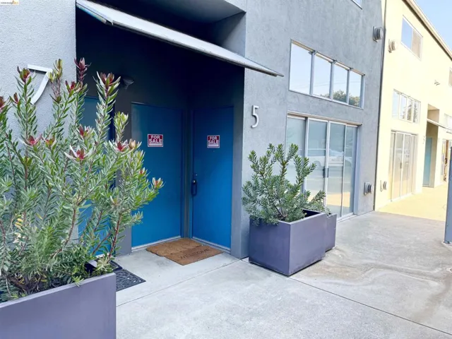 Modern building exterior featuring a textured stucco finish and contemporary blue double doors