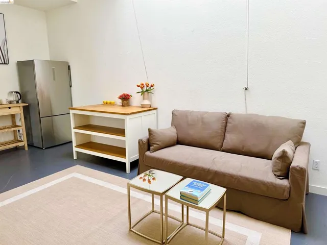 Stainless steel refrigerator, wood-finish flooring, and white walls