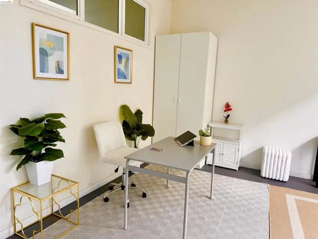 Spacious room featuring light-toned walls, high-set windows, and a built-in white wardrobe