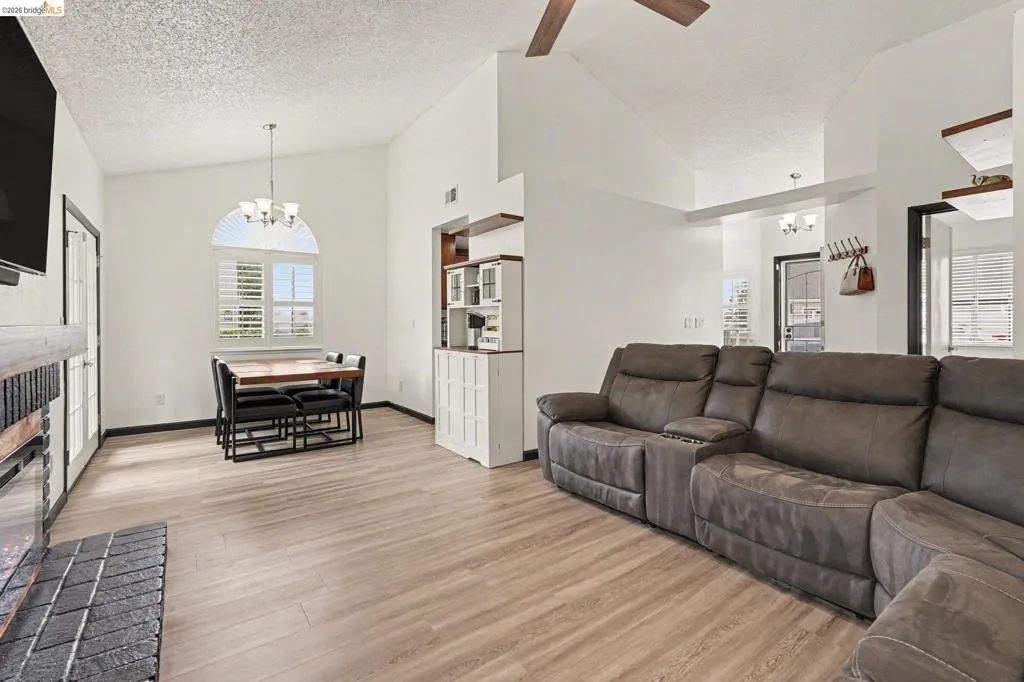Open concept living area featuring vaulted ceilings and wood-finish flooring