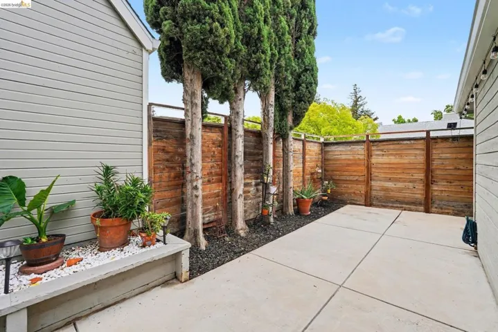 Private outdoor patio space featuring concrete paving and a privacy fence