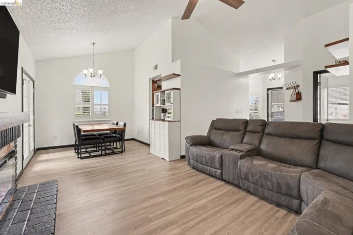 Open concept living area featuring vaulted ceilings and wood-finish flooring